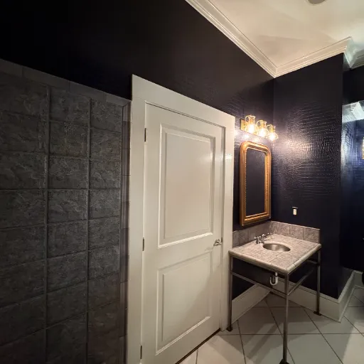 Marble and metal sink with tile accent wall 